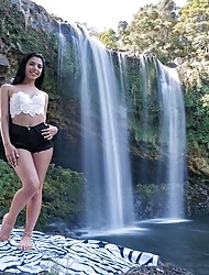 Latina teen Gina Valentina gets wet posing near a waterfall